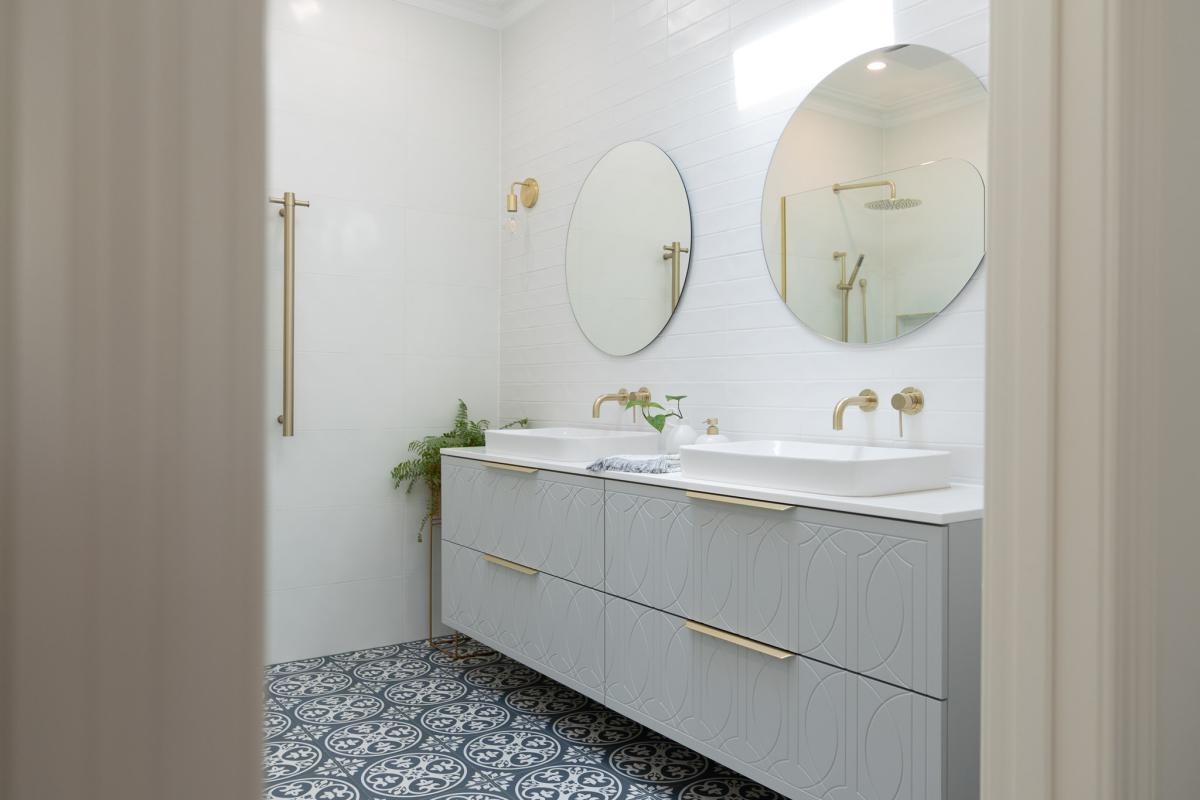 Modern bathroom with double vanity, brass tapware, mirrors