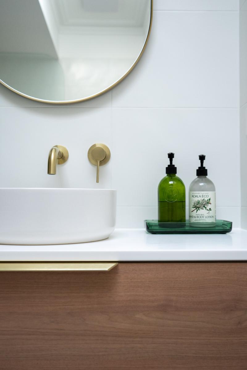 Modern bathroom vanity with brass tapware and accessories