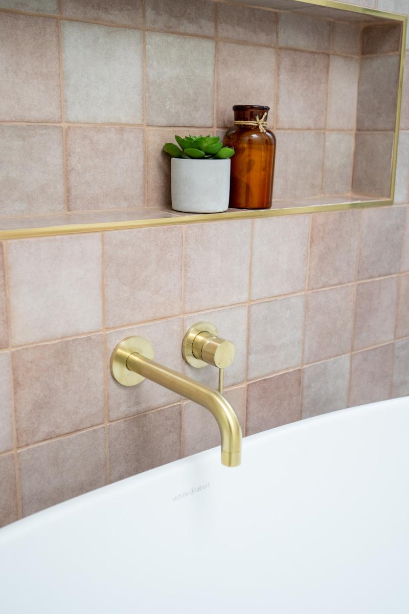 Modern bathroom with brass tapware and pink tiles
