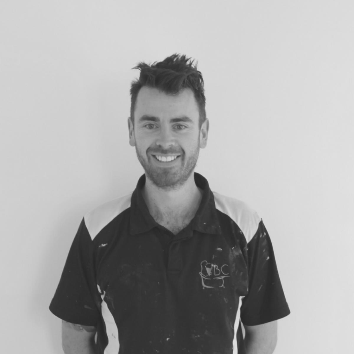 Portrait of a smiling bathroom renovation team member in branded work shirt