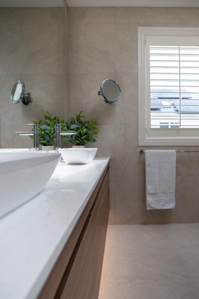 Modern bathroom with floating vanity, freestanding bath, and minimalist decor featuring plants and neutral tones