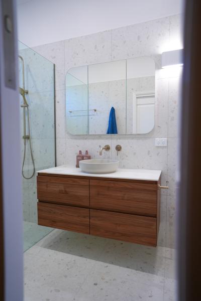 Modern bathroom vanity with round basin, mirrored cabinet and walk-in shower