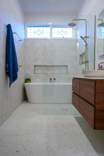 Modern white bathroom with built-in bath, walk-in shower and timber vanity